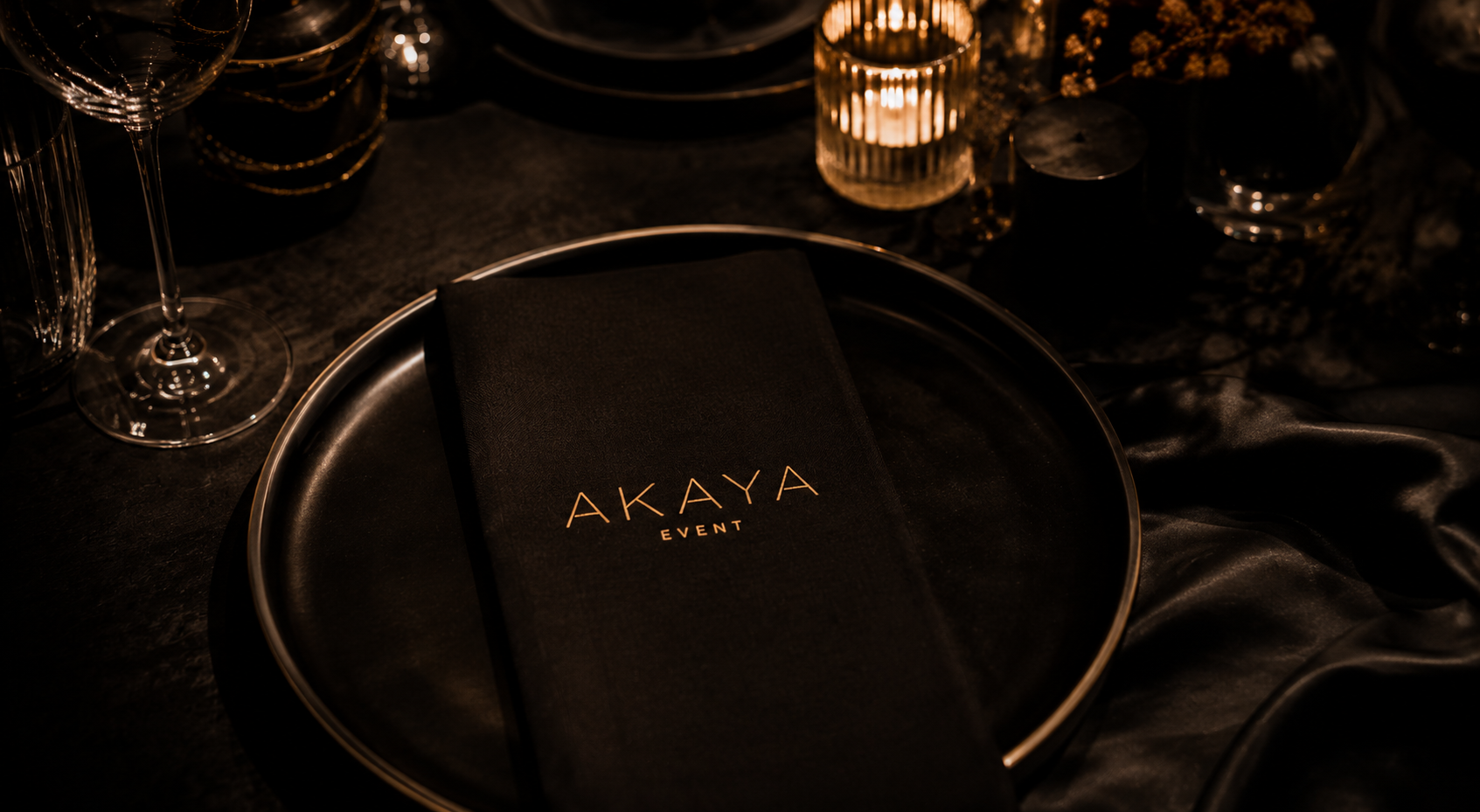 Elegant dukning med svart servett och AKAYA EVENT-logotyp